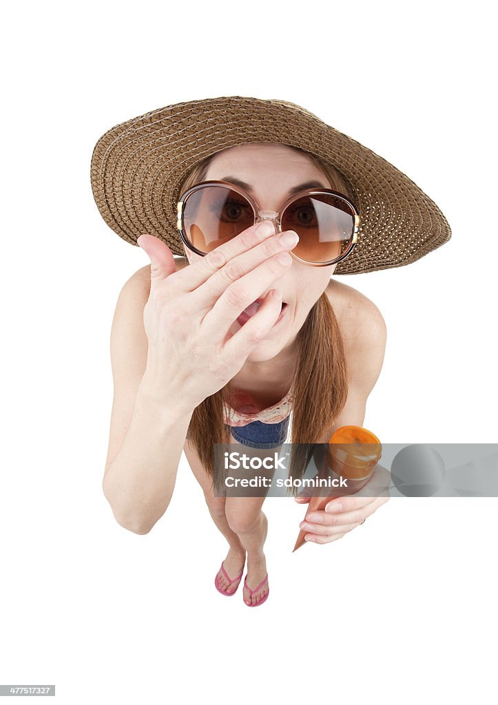 Fisheye Woman Applying Sunscreen To Nose A fisheye image of a woman applying sunscreen to her nose. Suntan Lotion Stock Photo