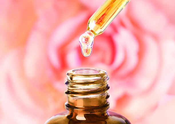 istock Essential rose oil water dropping from pipette to bottle. Aromatherapy. 477517450