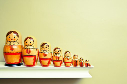 Toned image of a family of Russian nesting dolls all in a row on a ledge