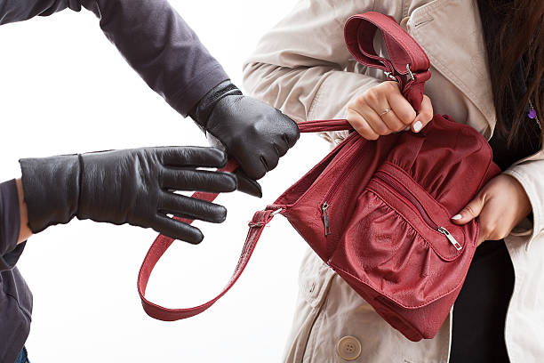 Thief holding a bag A closeup of a thief wearing gloves holding a woman's bag pickpocketing stock pictures, royalty-free photos & images