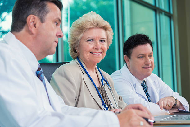 senior de médicos y profesionales de la salud en el hospital sala de juntas para reuniones - exam business caucasian board room fotografías e imágenes de stock