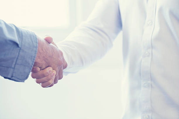 istock Close up of two people shaking hands. 477520288