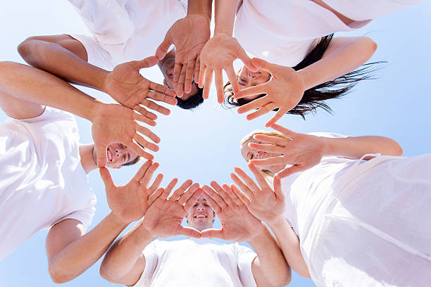 Young multiracial people stacking hands outdoor - Happy students friends celebrating together - Generation z concept - Focus on hands