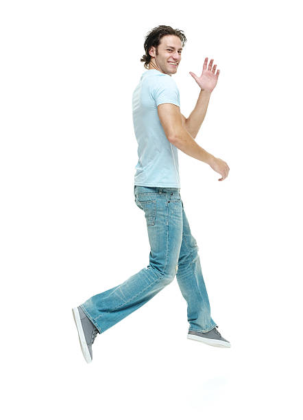 istock Cheerful casual man running and waving hand 477524246