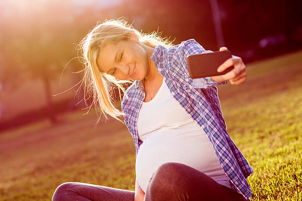 istock Pregnant woman taking selfie 477525224