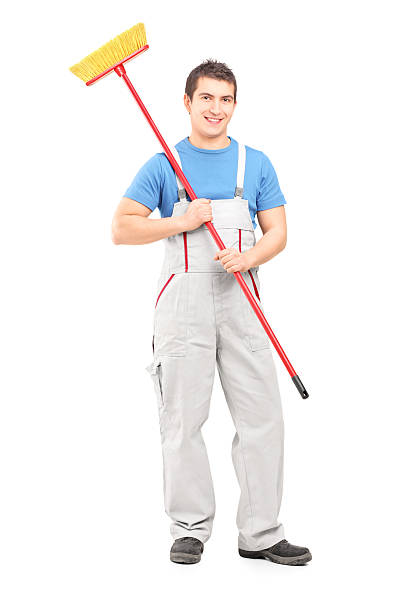 istock Smiling cleaner in uniform with a broom 477525913