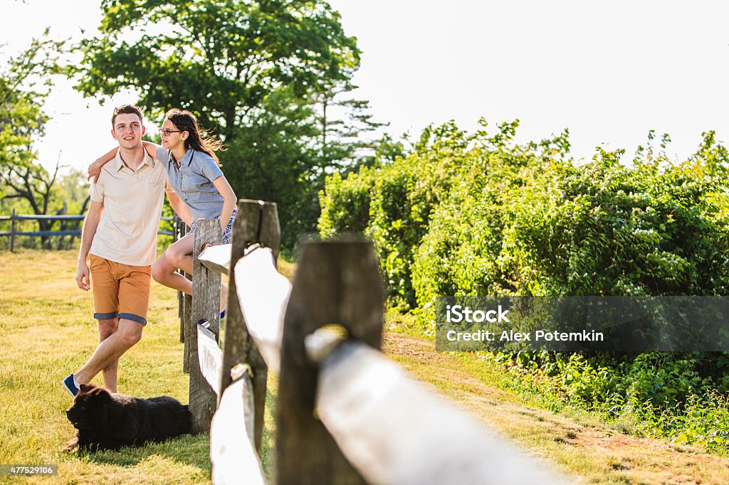 Young men, teenager girl and the black dog relaxing outdoor Young men, teenager girl and the black Chow Chow dog relaxing outdoor in the Sands Point's park, next to the ocean 12-13 Years Stock Photo