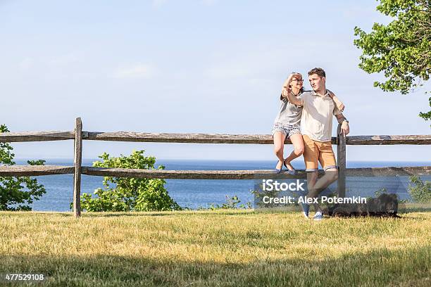 Young Men Teenager Girl And The Black Dog Relaxing Outdoor Stock Photo - Download Image Now