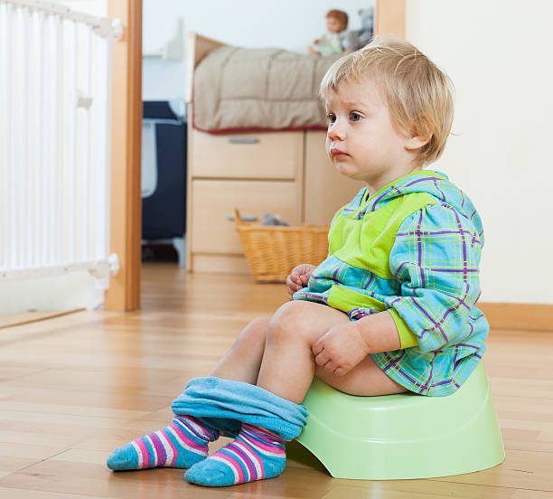 istock Baby  sitting on green potty 477529253