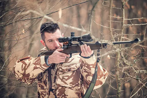 Photo of Man holding sniper and shooting on an open season