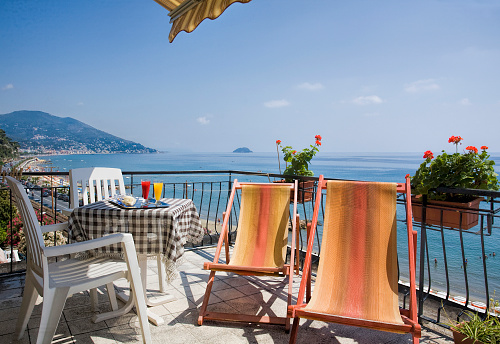table with drink above the sea, on ligurian riviera, and isle of Gallinara on the background