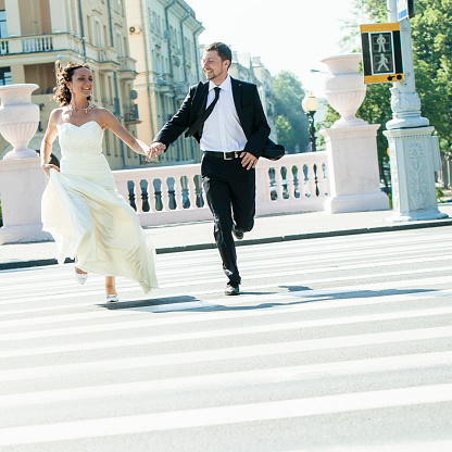 The real wedding in Minsk, Belarus (Europe). Bride and groom run across the street