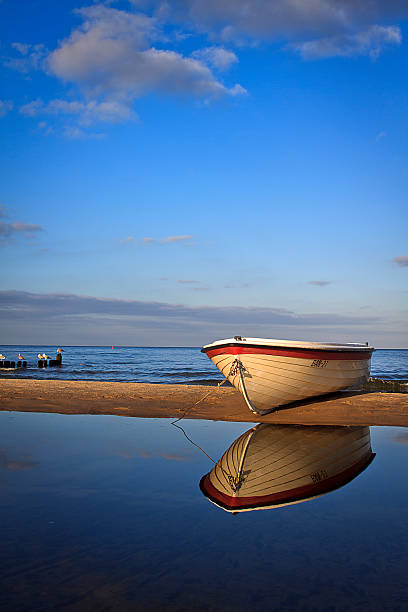 istock White fisherboat on the sand 477534936