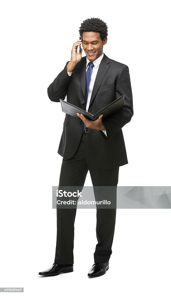 Young business man talking on the phone A full body shot of a young latin business man talking on the phone. Isolated on a white background. Holding Stock Photo