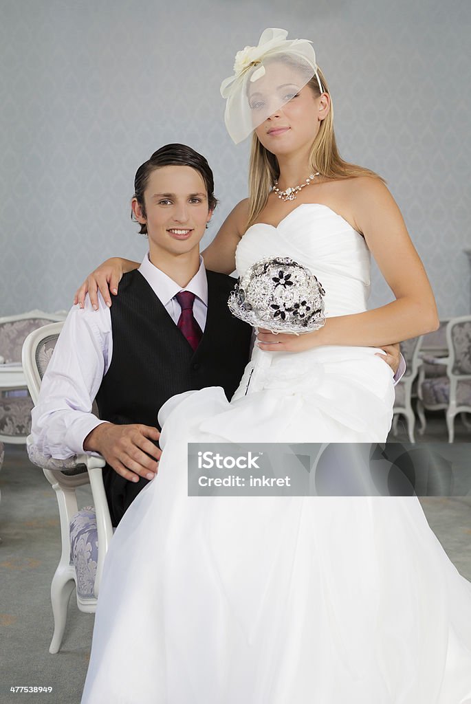 Wedding couple Bride sitting in a lap of her much younger husband. Adult Stock Photo