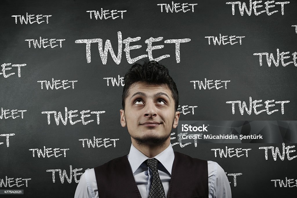 Tweet board Man thinking in front of "Tweet" words written blackboard 20-29 Years Stock Photo