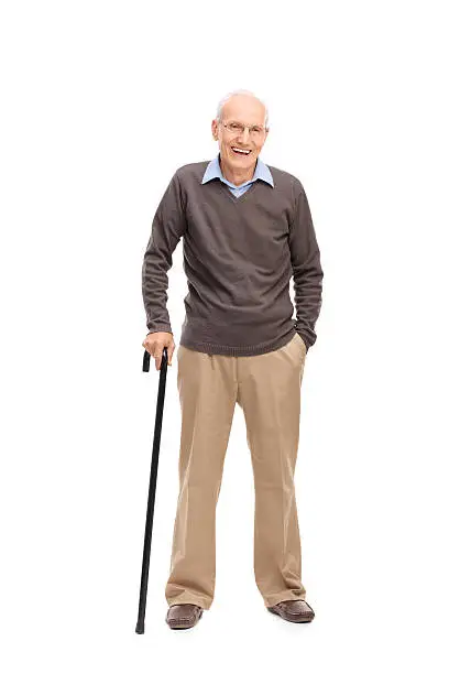 Full length portrait of a senior man with a cane smiling and posing isolated on white background