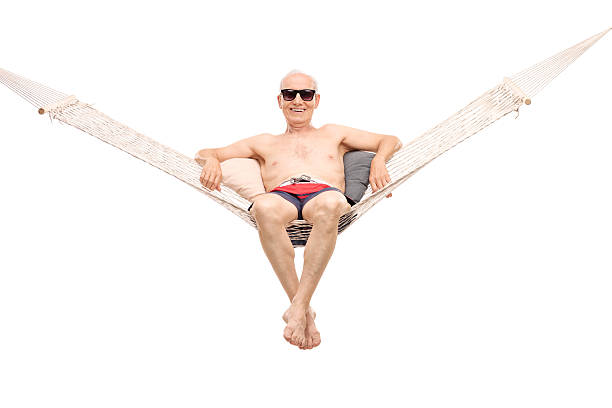 istock Relaxed senior man sitting in a comfortable hammock 477543182
