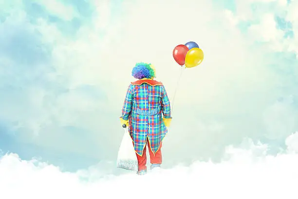 clown with balloon lost in the clouds