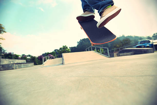 istock skateboarder legs doing a trick ollie at skatepark 477547654