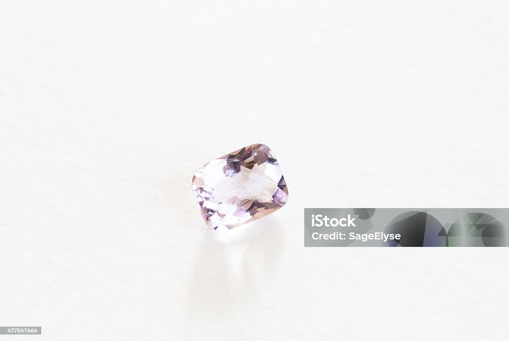 faceted amethyst A single rectangular lavender amethyst stone that is faceted and polished.  Studio shot against a white background. 2015 Stock Photo