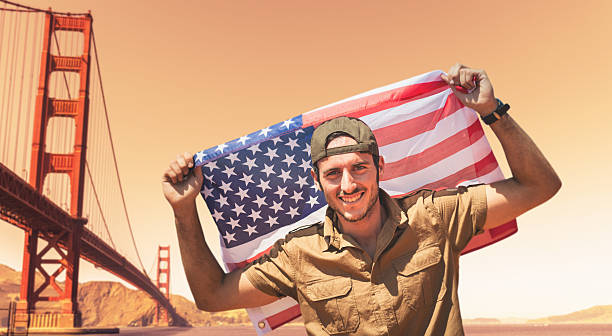 istock Tourist with us flag on golden gate bridge 477548535