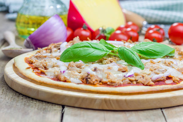 pizza com atum, peixe em uma tábua de madeira - pizza tuna prepared fish cheese - fotografias e filmes do acervo