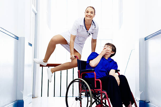 улыбается медсестра в пожилых прыжкам поражены пациента в инвалидных креслах: life's fun! - naughty nurse стоковые фото и изображения
