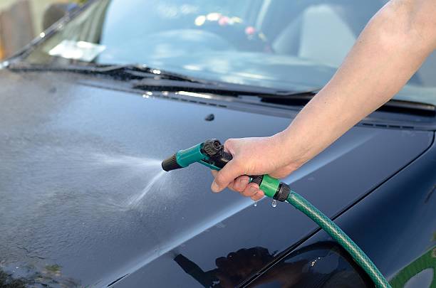 istock male hand washes the car with a hose 477549098