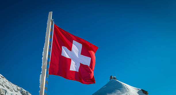 istock Swiss flag on Alpine mountain peak beside Sphinx Observatory Switzerland 477549791