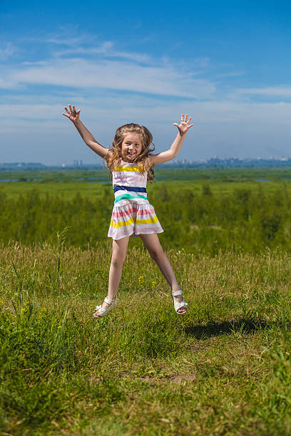 istock Baby girl jumping on a meadow 477549792