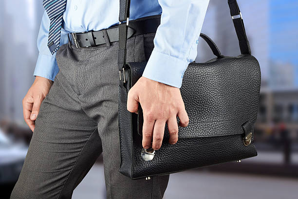 istock Businessman walking and holding  a  leather briefcase in his hand 477550056