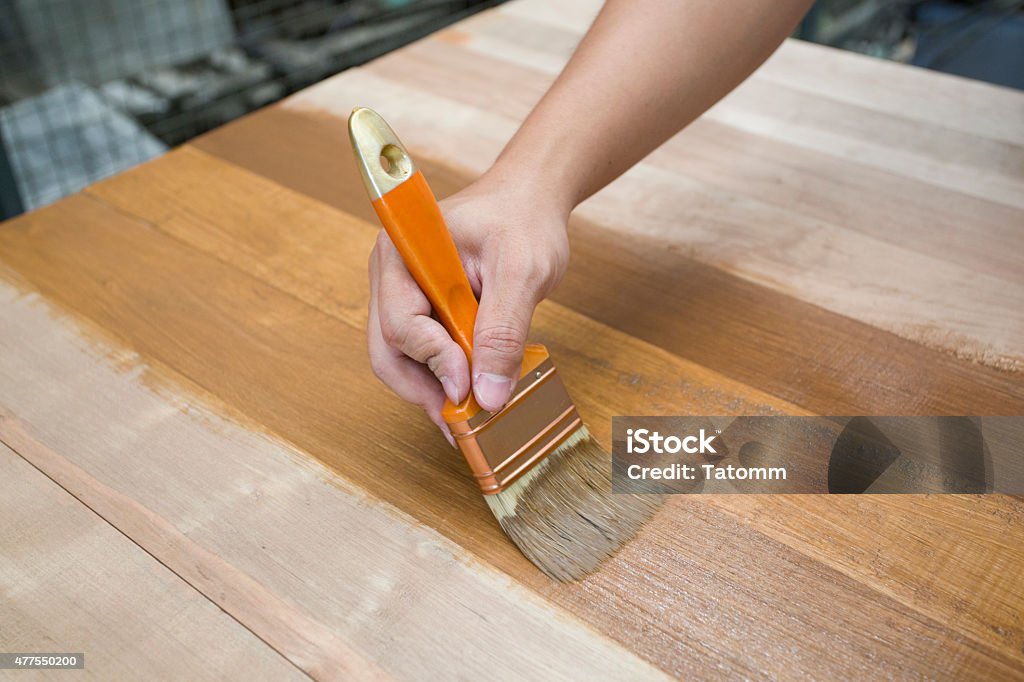 Applying protective varnish on a wooden furniture Furniture Stock Photo