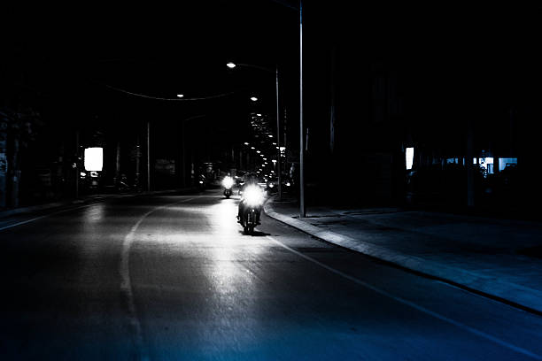 A bride and a groom riding a scooter in night Thailand on Koh Samui