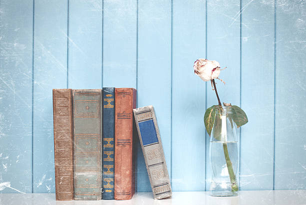 istock Books pile and white rose in the bottle 477554084