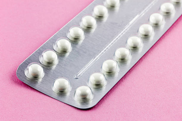 Birth control Pills on a pink background stock photo