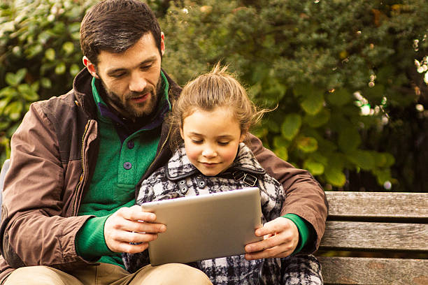 istock Father And Daughter playing with a Tablet 477557653
