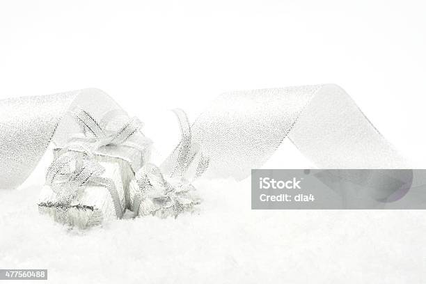 Three Silver Christmas Gifts With Silver Ribbon On Snow Stock Photo - Download Image Now