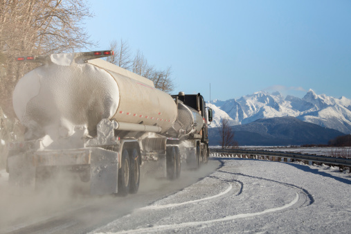 Tanker truck on a narrow Alaskan highway in winter.