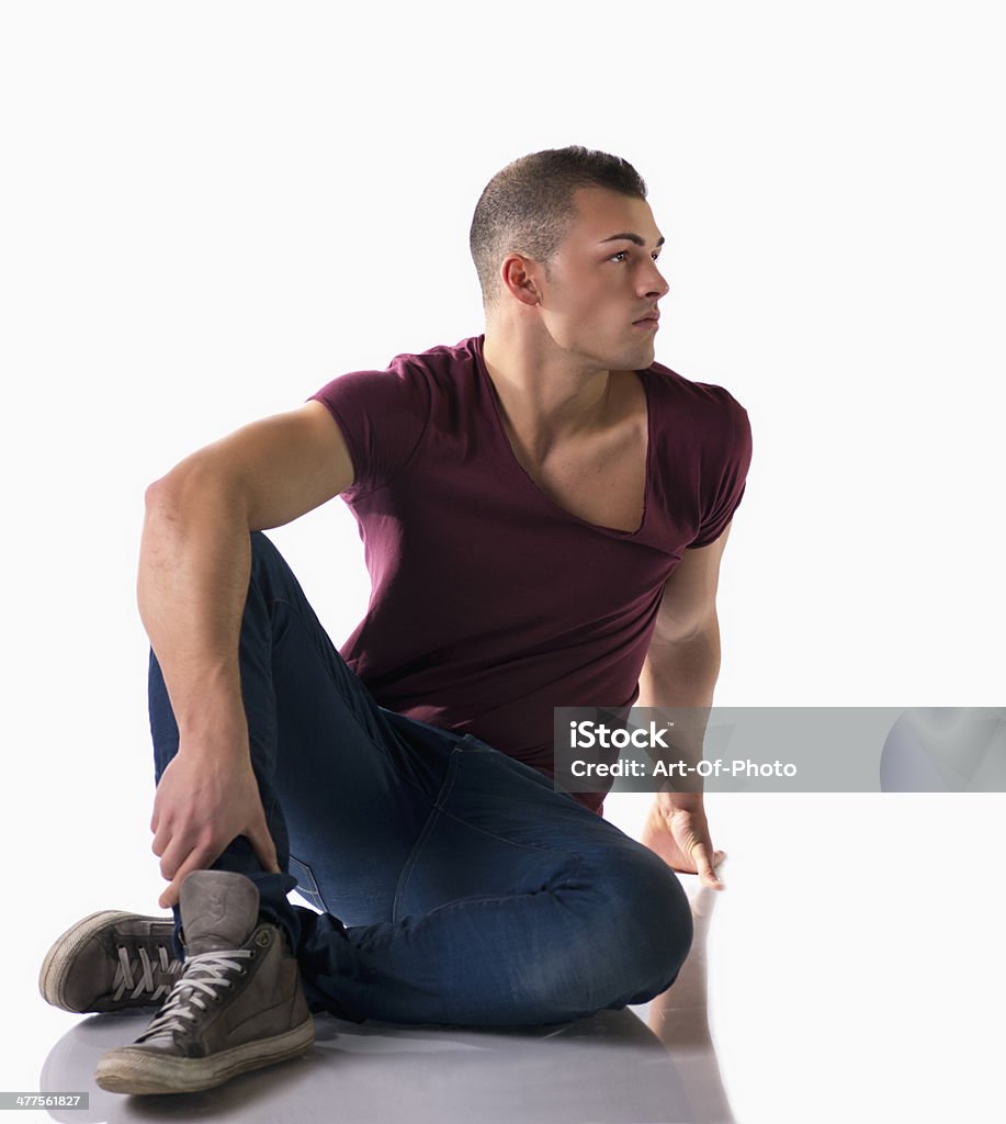 Foto de cuerpo completo del hombre joven atractivo sentado en el suelo - Foto de stock de 18-19 años libre de derechos