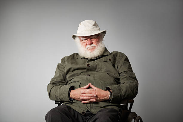 grumpy homme senior sur fauteuil roulant - uncertainty weakness contemplation sullen photos et images de collection