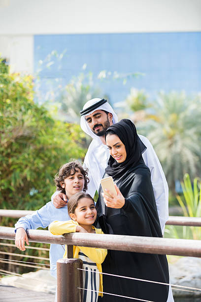 istock Middle Eastern Family Looking at Selfie on Cellphone in Park 477564032