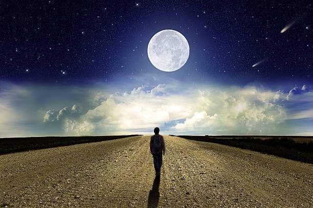 istock Man walking on the road at night 477564178