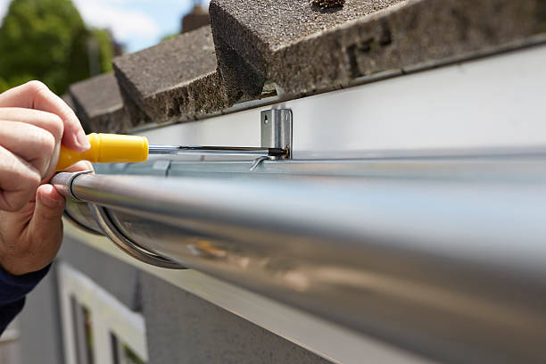 Close Up Of Man Replacing Guttering On Exterior Of House stock photo