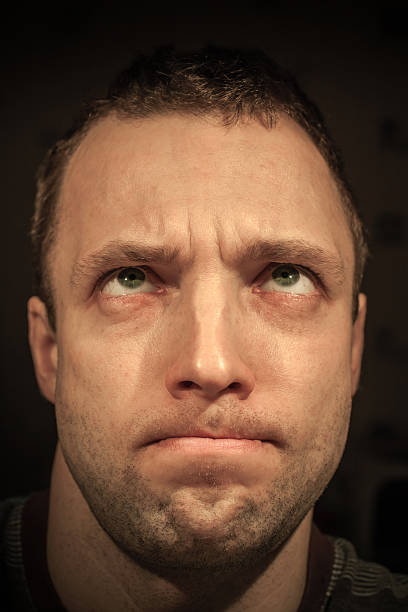 istock Young thinking Caucasian man closeup portrait on dark background 477564941