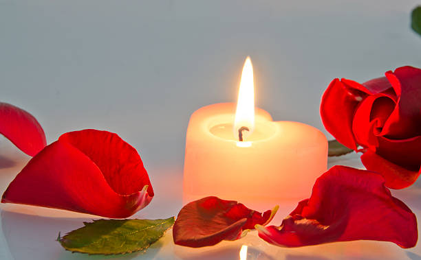 istock burning candle in rose petals 477565825