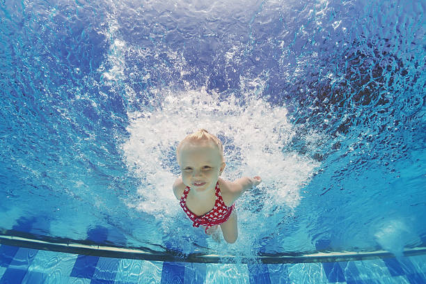 child swimming underwater with splashes in the pool - baby swim under water bildbanksfoton och bilder