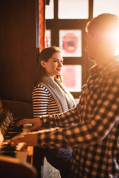 istock Young man playing piano for his girlfriend. 477567250