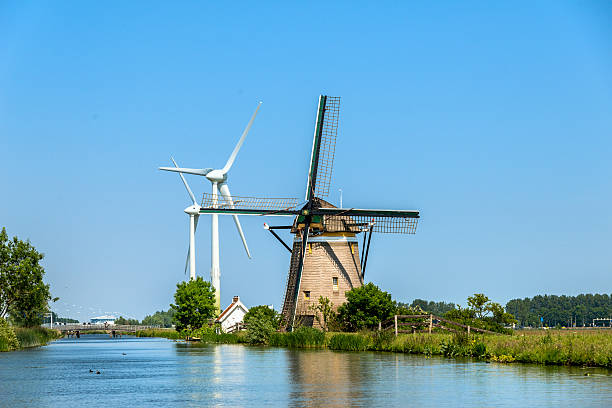 nouveaux et anciens moulins à vent, au bord de l'eau dans les pays-bas. - polder windmill space landscape photos et images de collection