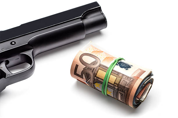 istock Bunch of euro banknotes with a gun 477573508